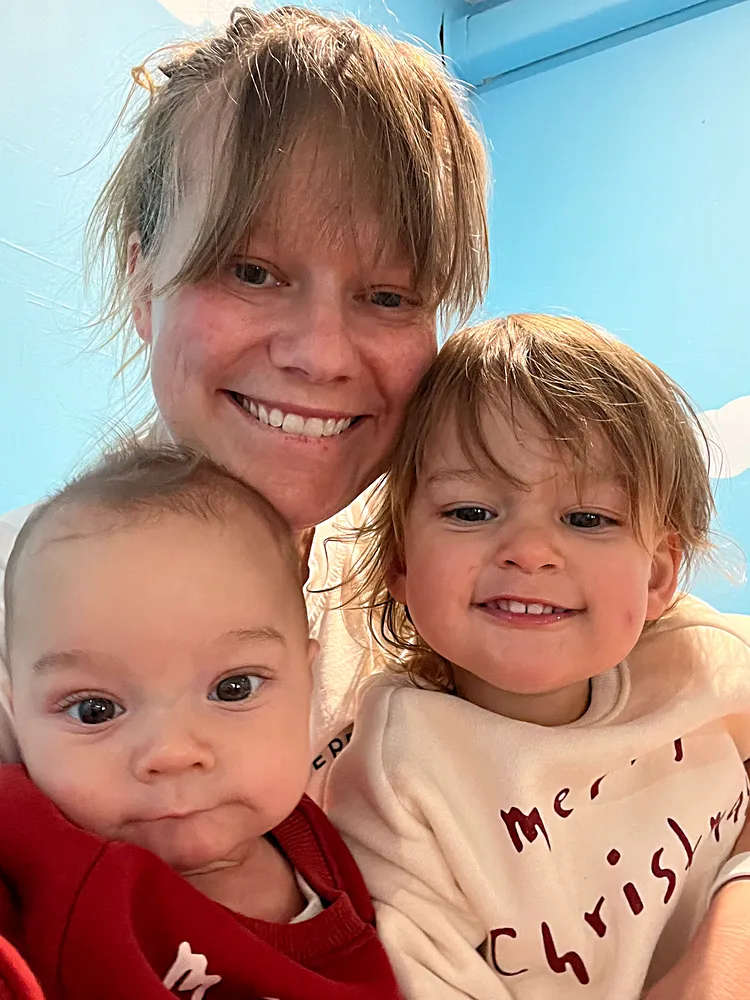 Black kettle with long pour spot and angled body on marble counter next to coffee mug and pour-over system.