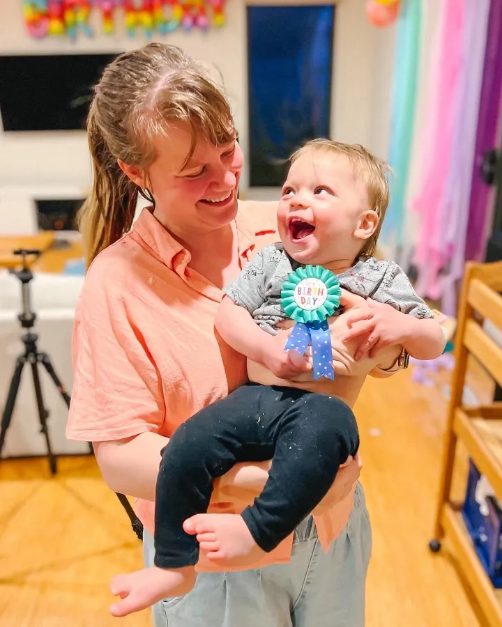 Kettle spout pouring boiling water into coffee grounds in pour-over mug.